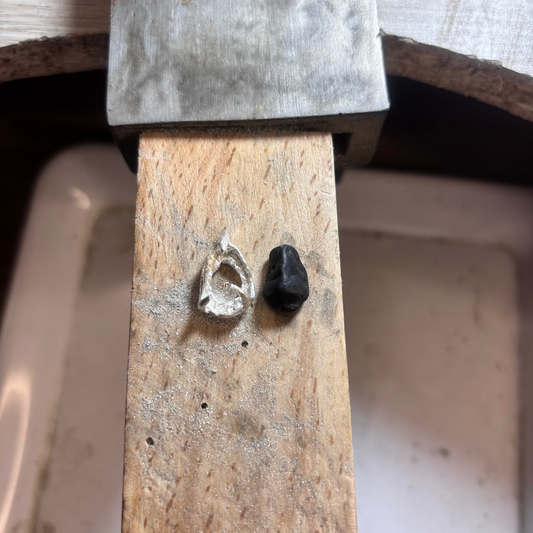Close-up of black stone pendant showing prong setting