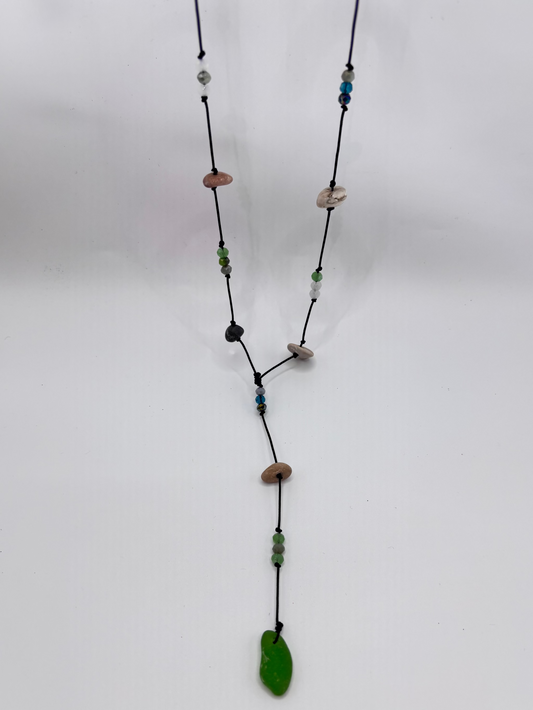 Long necklace with multicolored beads and a green pendant on a white background