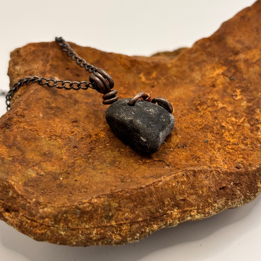 Close-up of copper and red wire wrapped black stone pendant