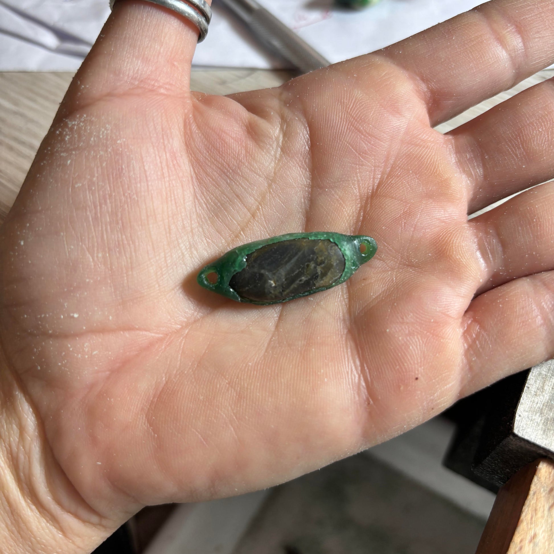 bracelet in wax with a black stone on a rock against a white background