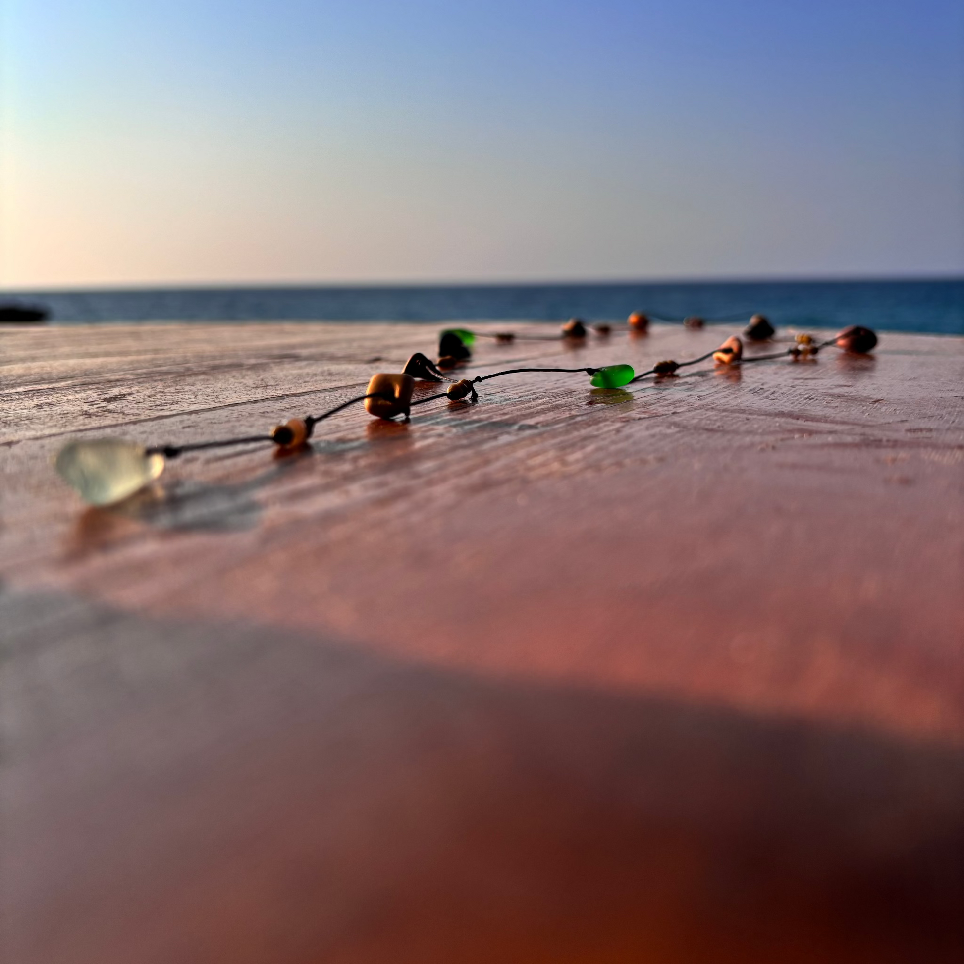 Close-up of a 7ajra necklace made with twelve raw stones, each uniquely shaped and textured.