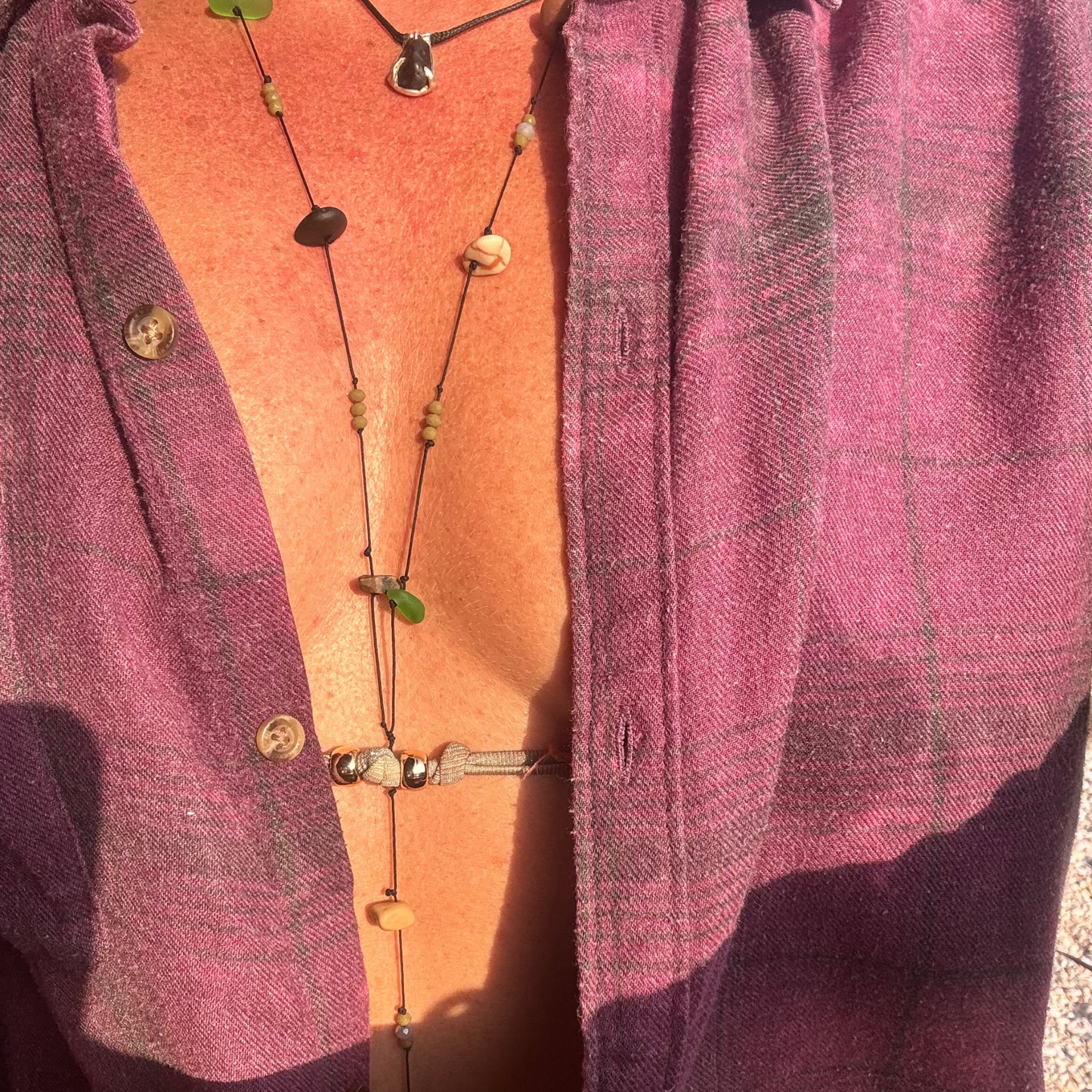 Close-up of a 7ajra necklace made with twelve raw stones, each uniquely shaped and textured.