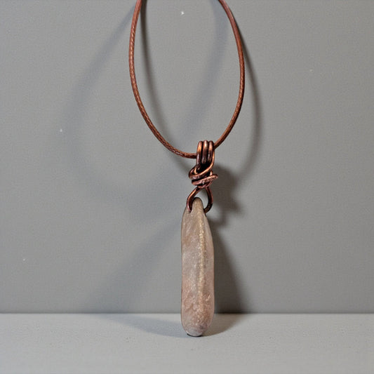 Necklace with a stone pendant on a gray background