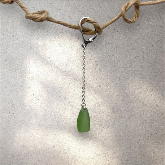 Green raw silver glass with silver chain on a gray background

