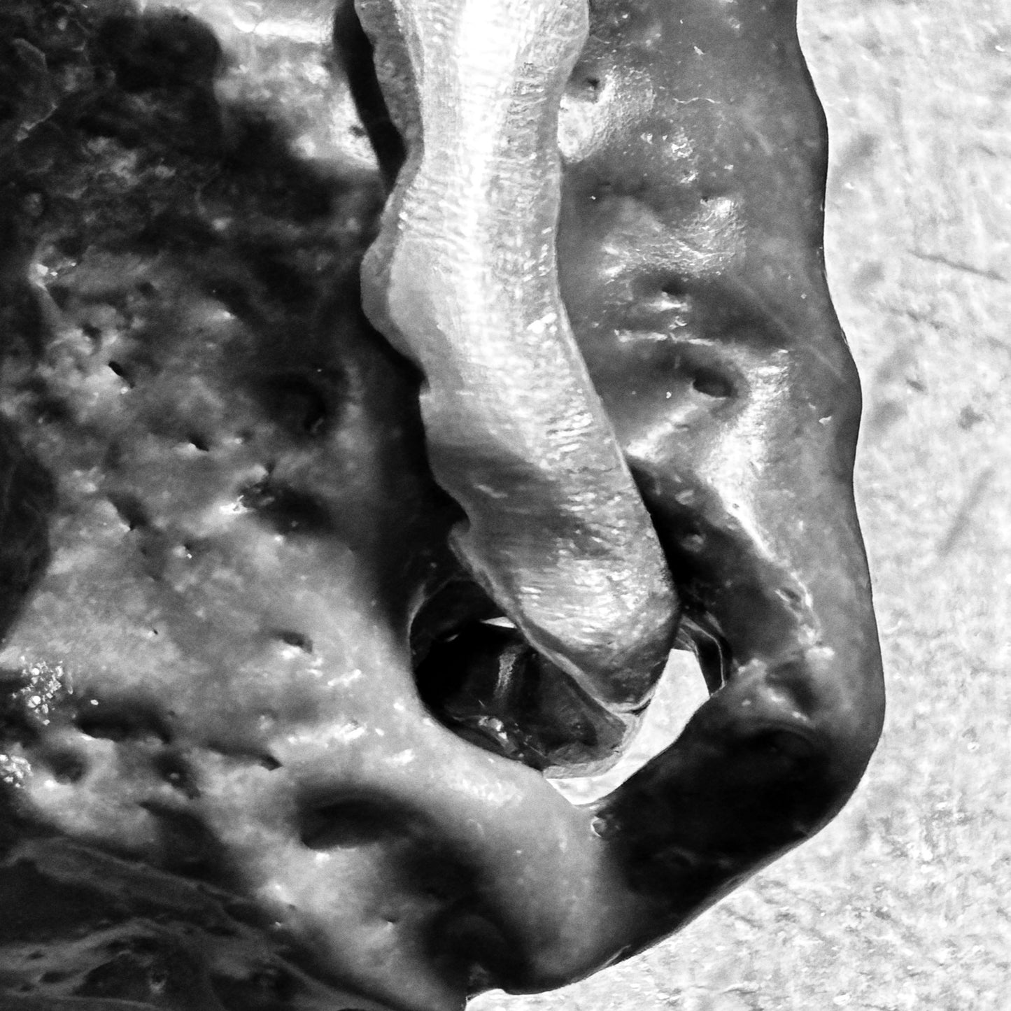 Close up on silver pendant holding a stone with its natural hole handmade jewelry.