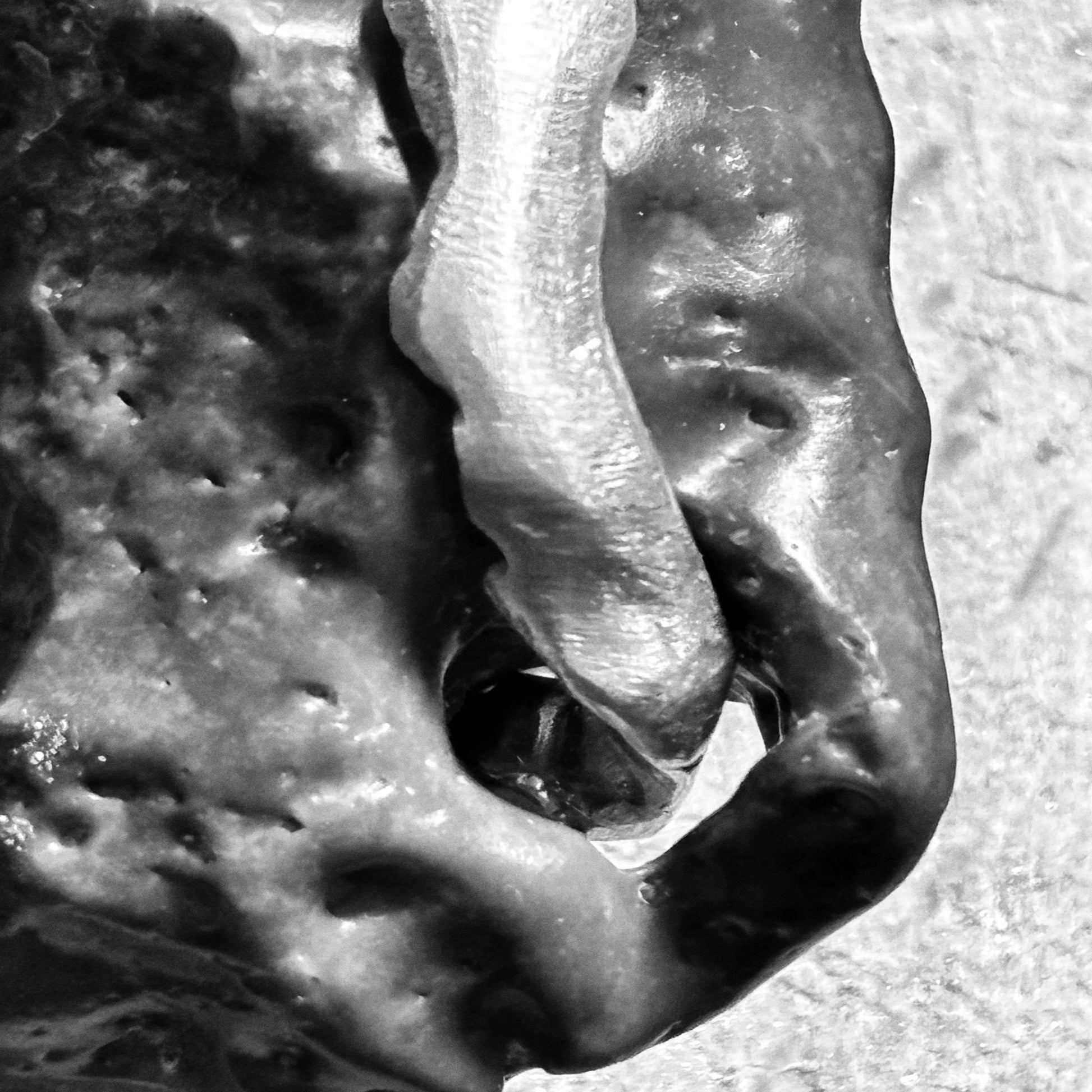 Close up on silver pendant holding a stone with its natural hole handmade jewelry.