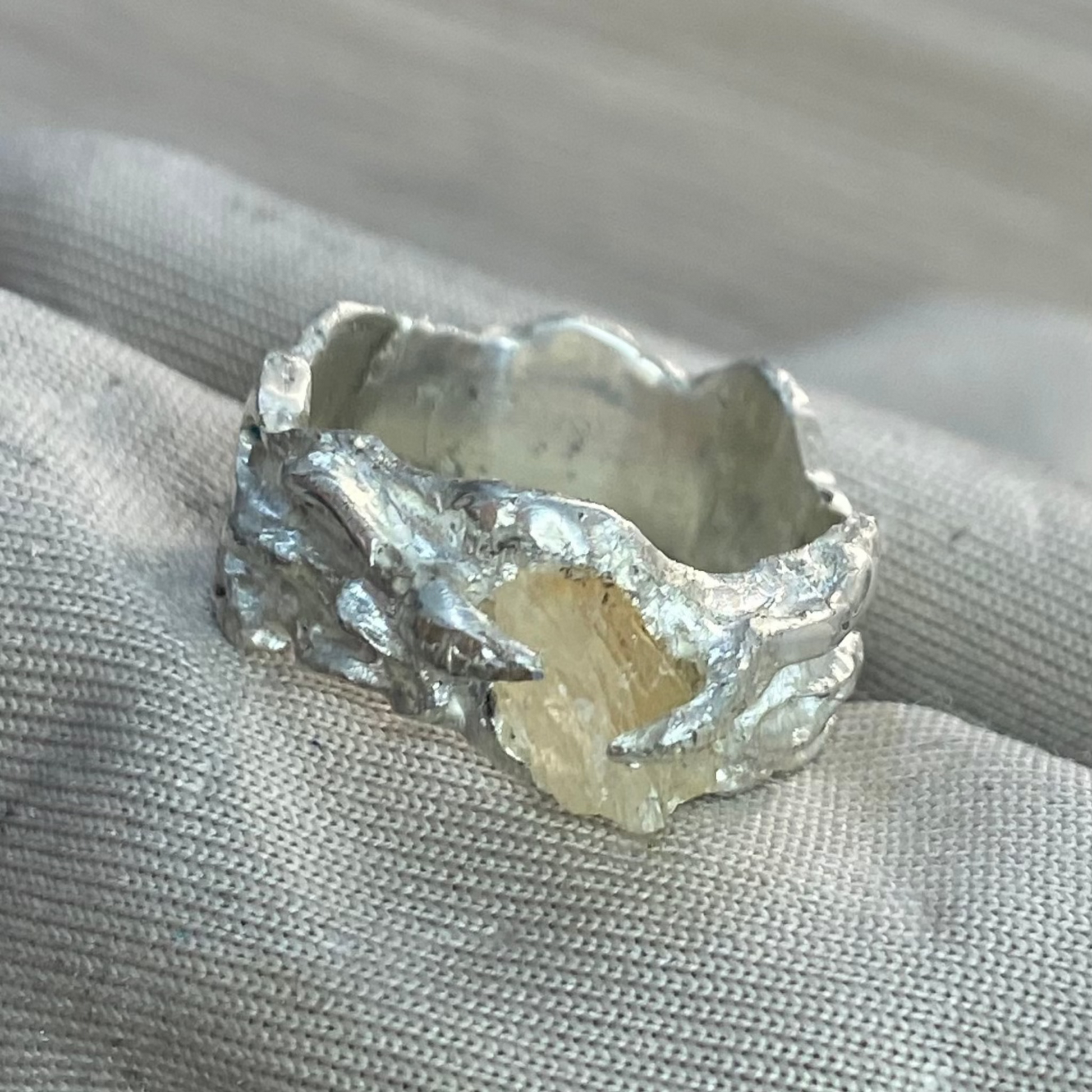 Close-up of translucent calcite stone in raw silver setting