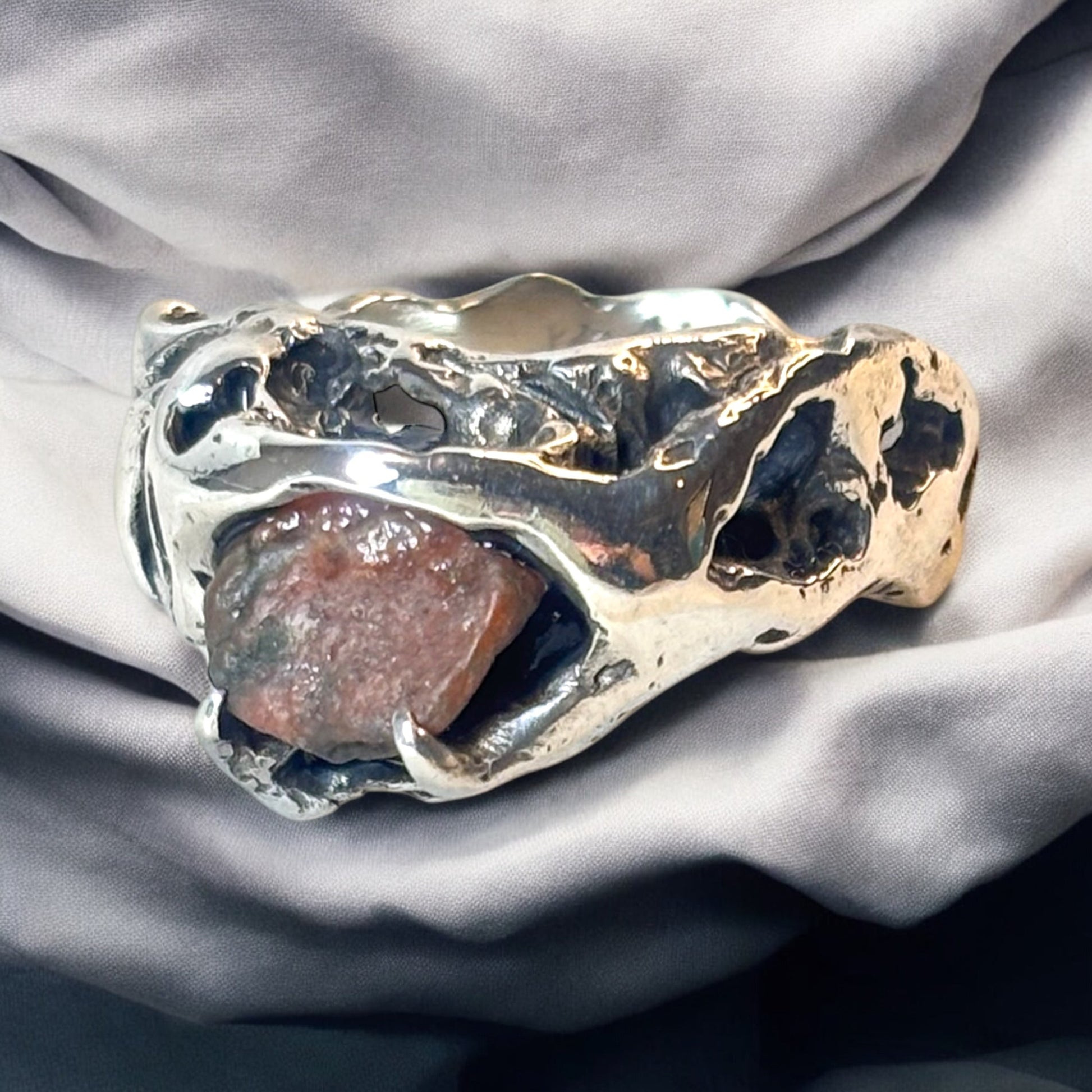 Silver ring named Clessidera with sculpted holes and raw stone