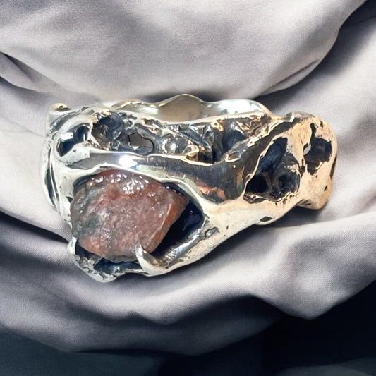 Silver ring named Clessidera with sculpted holes and raw stone