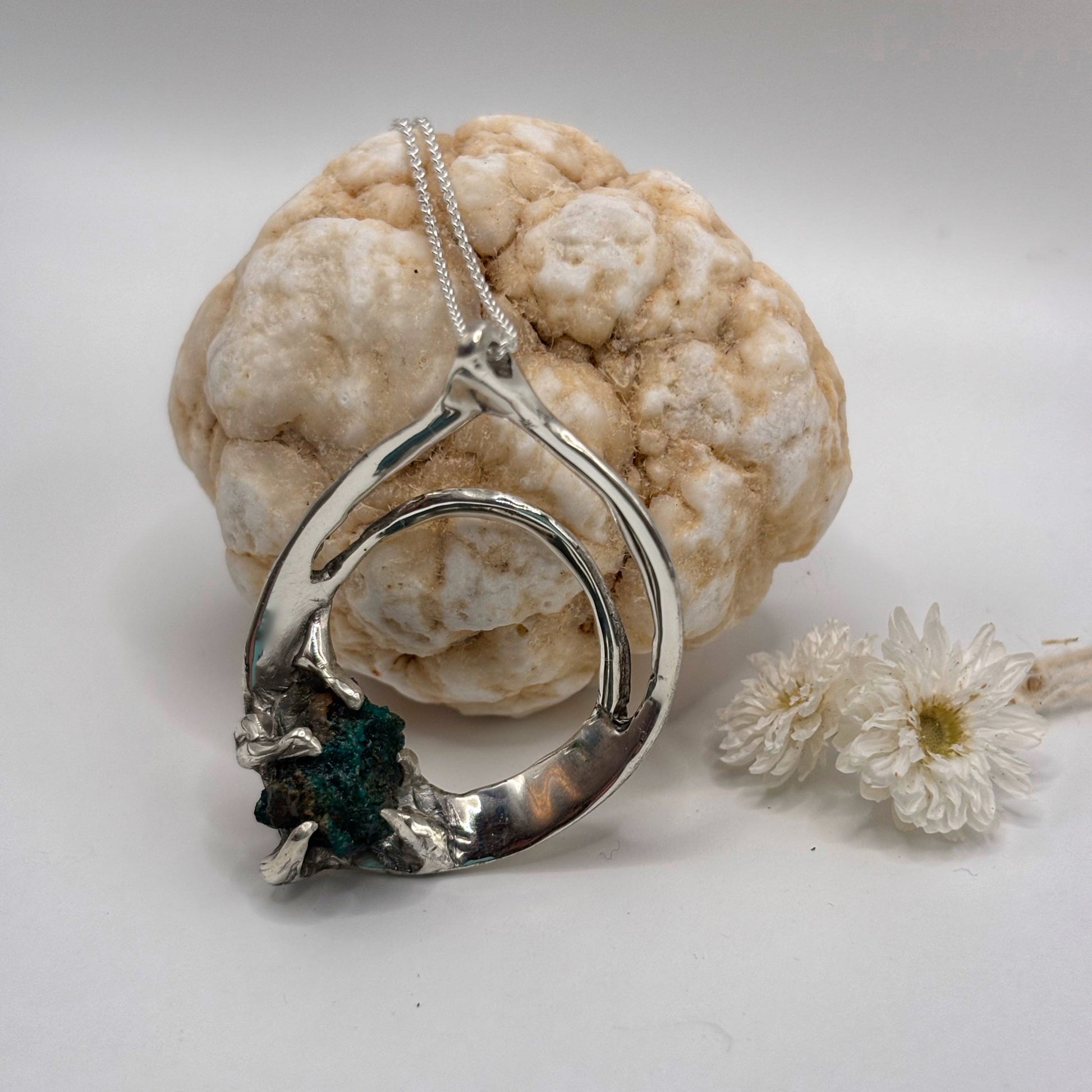 Silver necklace with a unique pendant on a white background