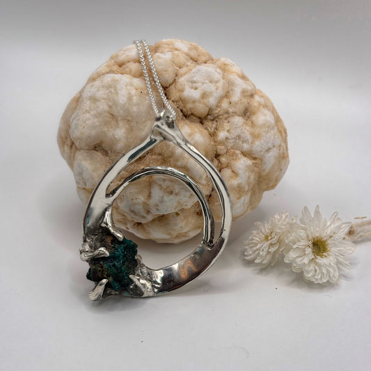 Silver necklace with a unique pendant on a white background