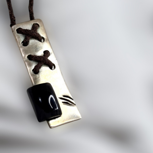 Silver pendant with corset-style lace detailing and black onyx