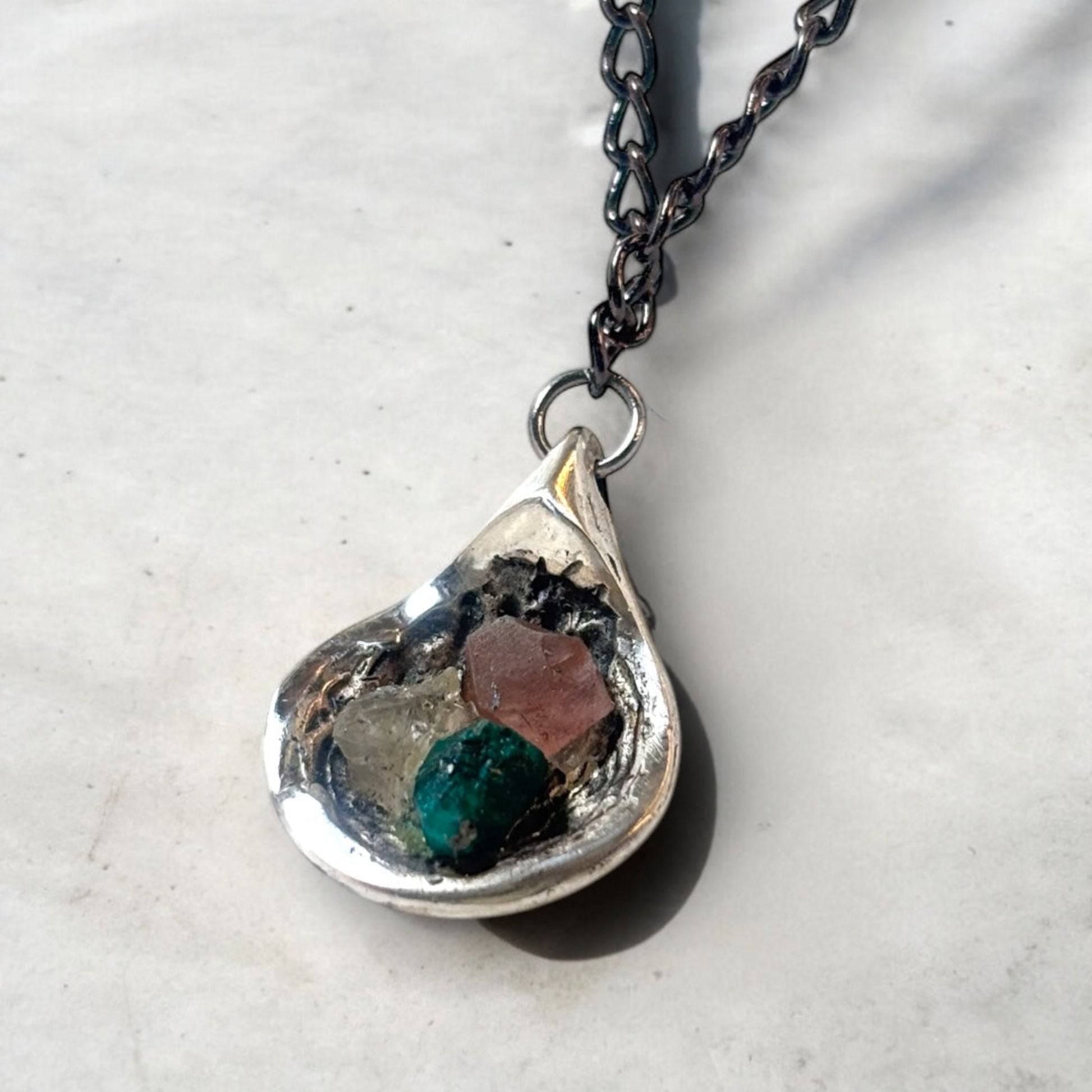 Silver pendant holding three raw stones in Lebanese flag colors