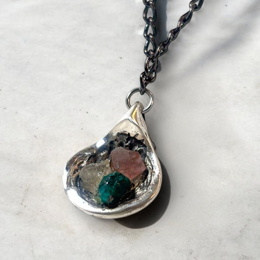 Silver pendant holding three raw stones in Lebanese flag colors