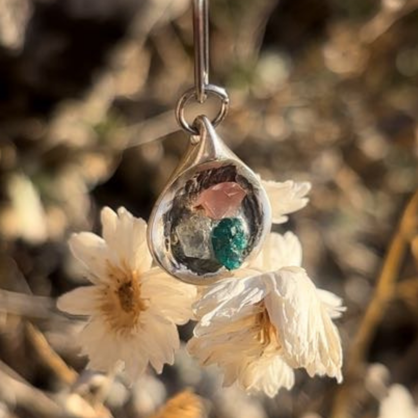 Close-up of red, white, and green stones in silver setting