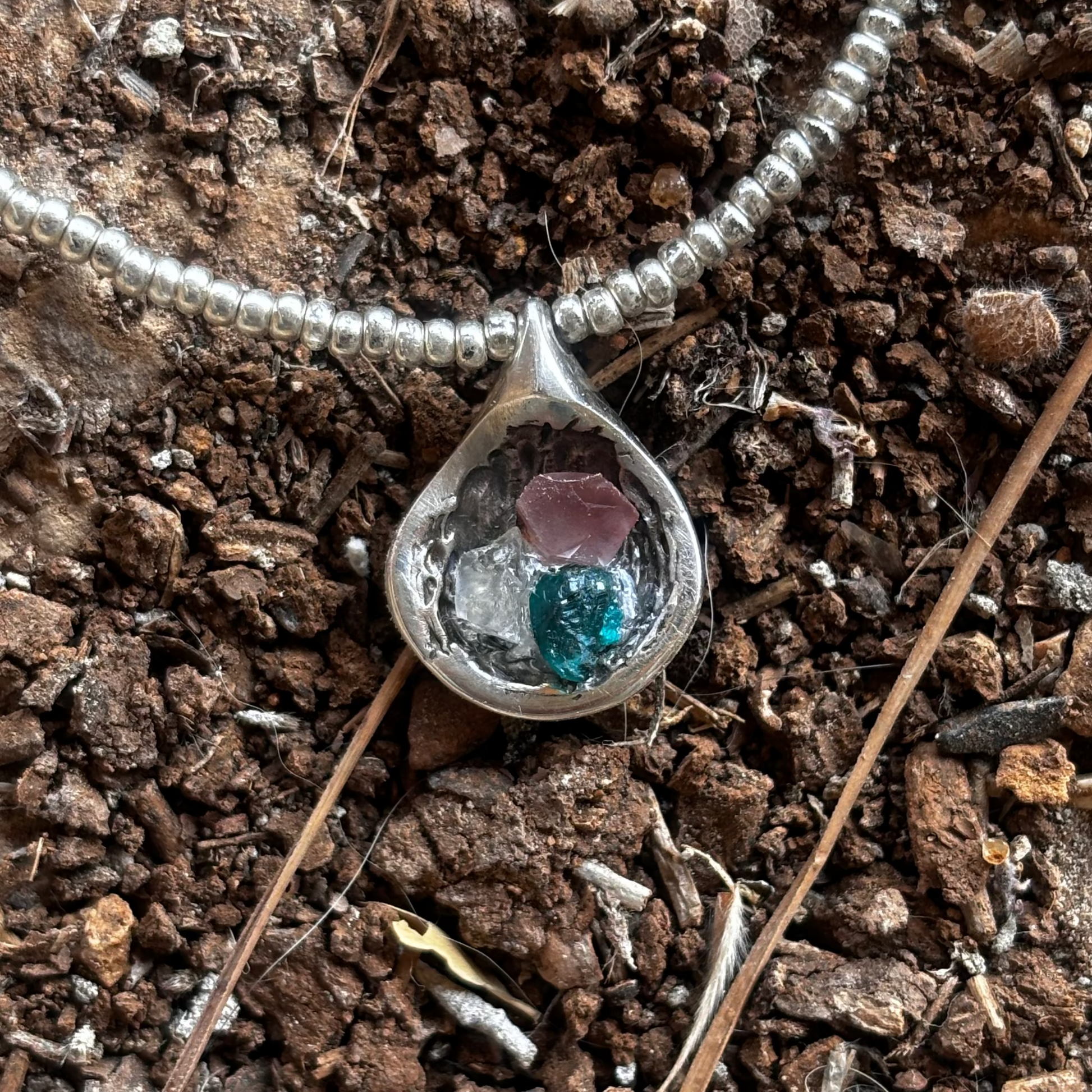 Silver pendant with Lebanese flag stones, worn detail shot