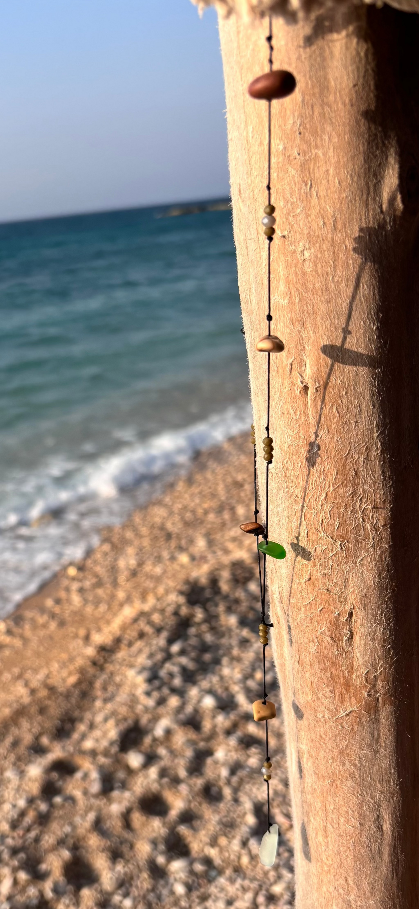 Close-up of a 7ajra necklace made with twelve raw stones, each uniquely shaped and textured.