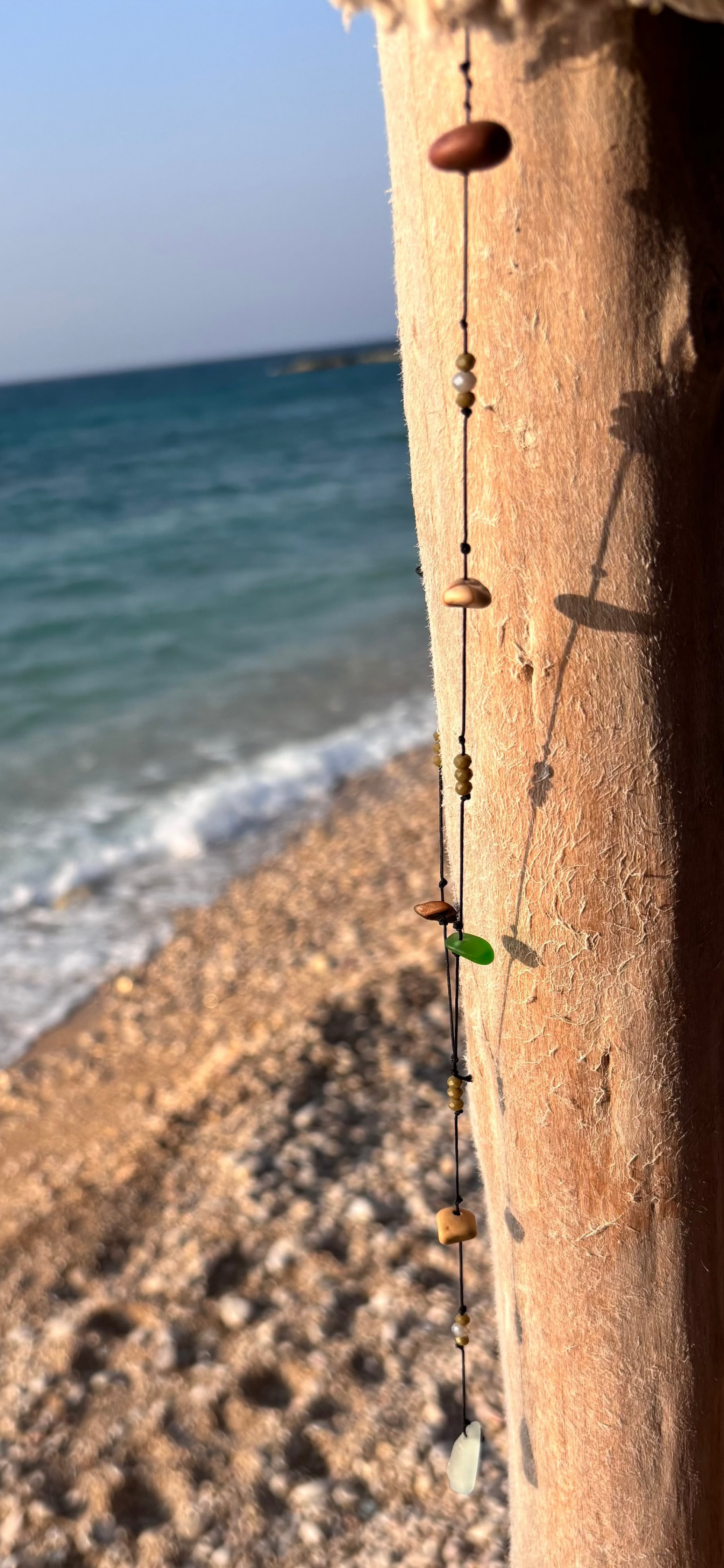 Close-up of a 7ajra necklace made with twelve raw stones, each uniquely shaped and textured.