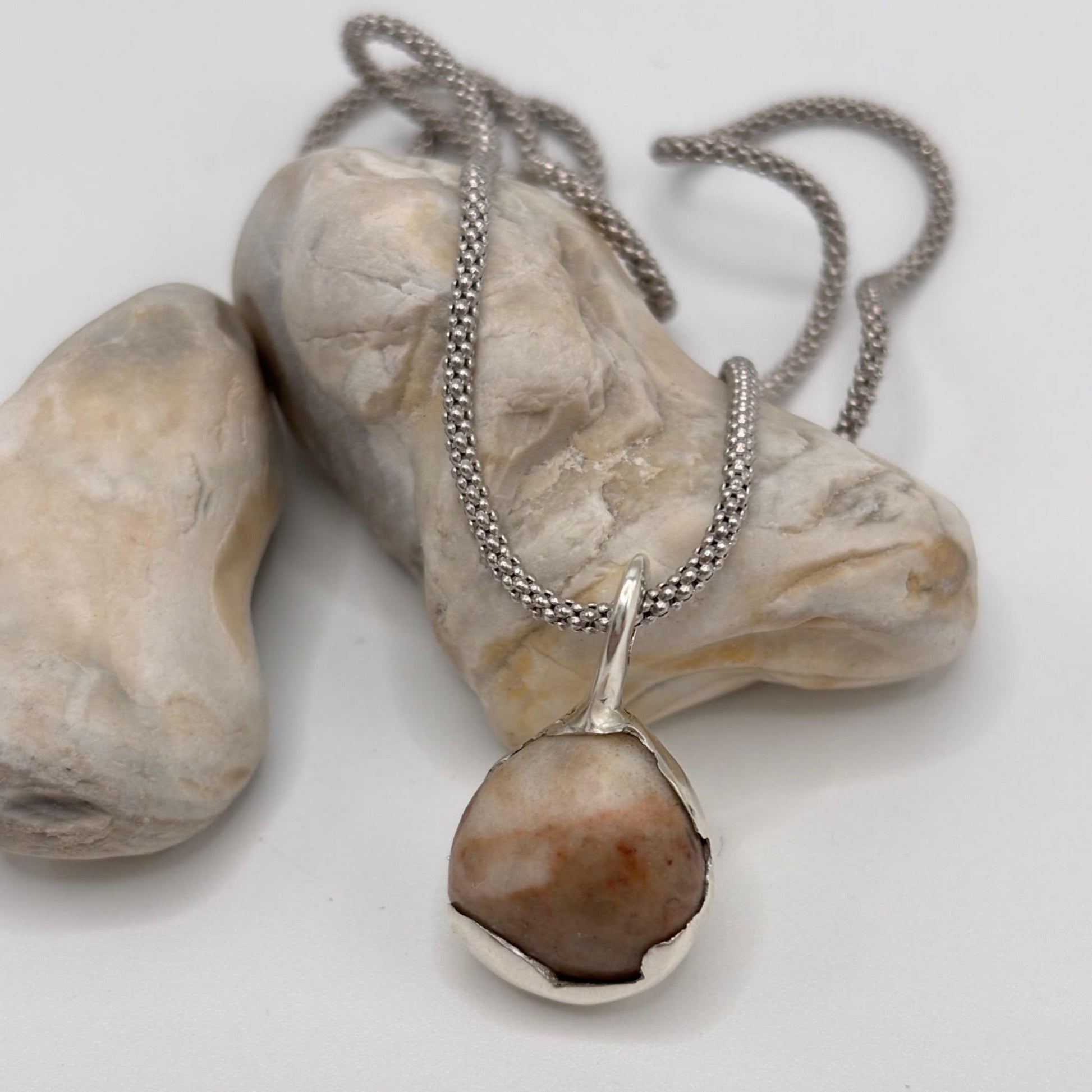 Necklace with a pendant on a stone surface
