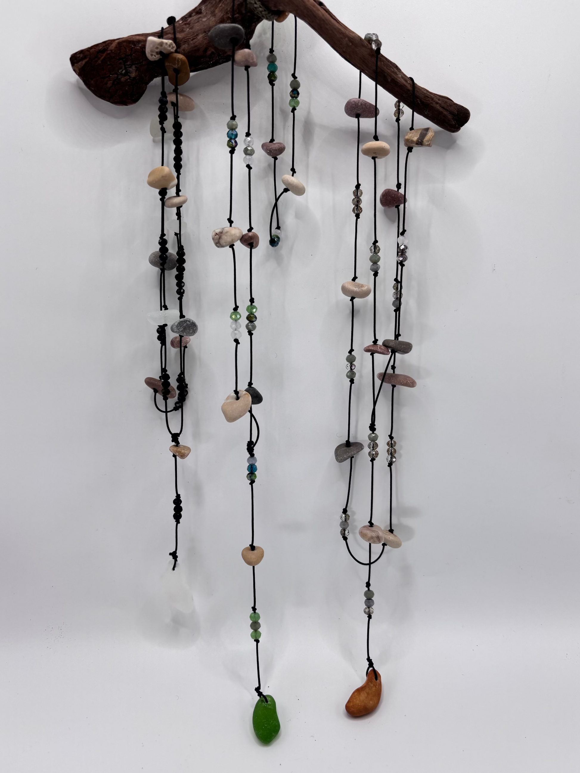 necklaces hanging with pebbles and beads on a white background