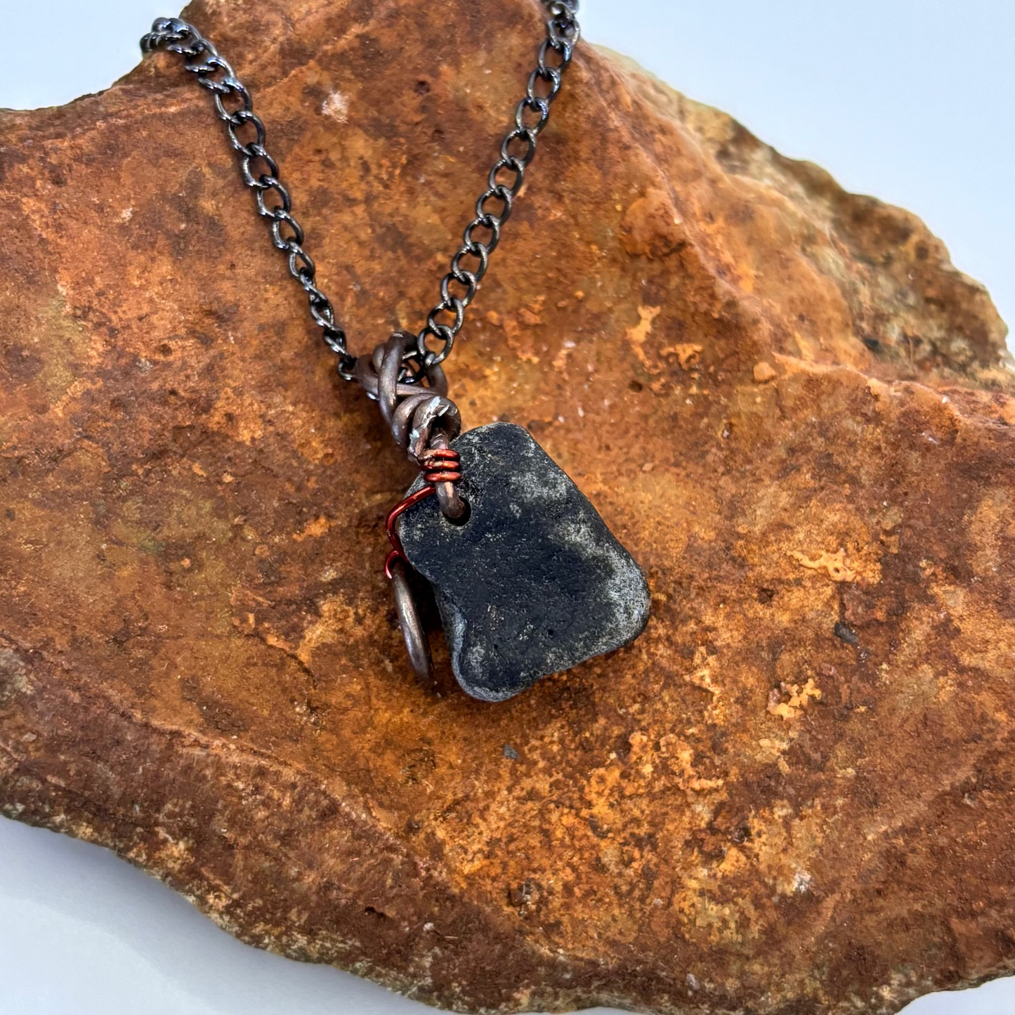 Necklace with a pendant on a textured stone surface