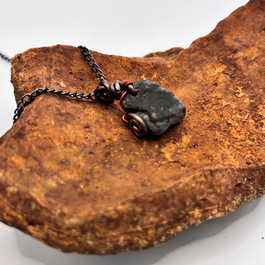 Black raw beach stone wrapped in copper wire necklace pendant