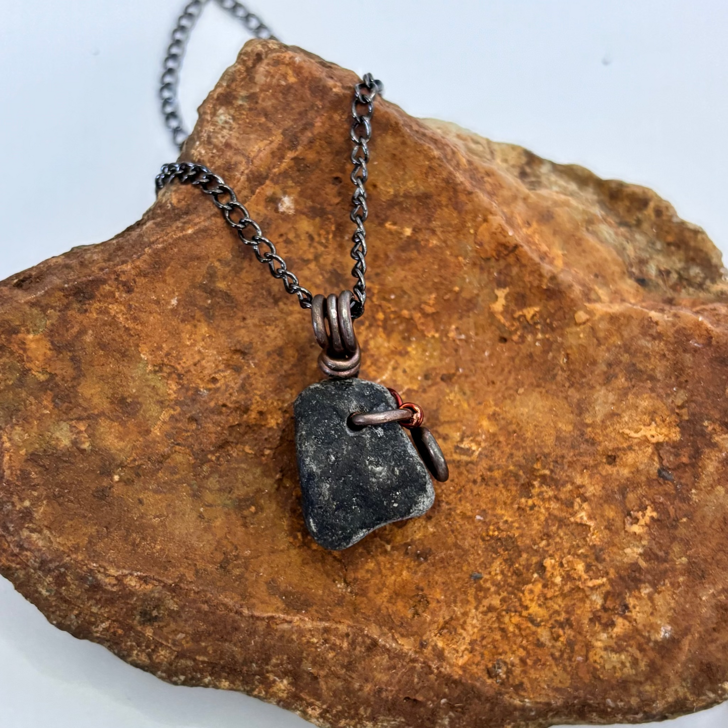 Black beach stone necklace on black chain, side view