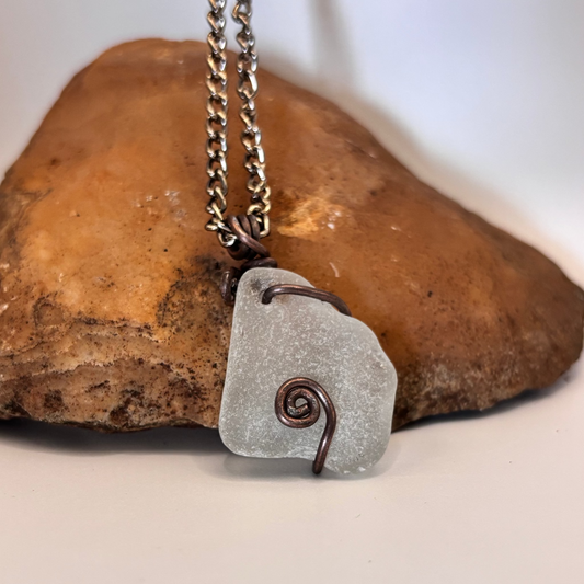 White sea glass pendant wrapped in copper wire on black chain