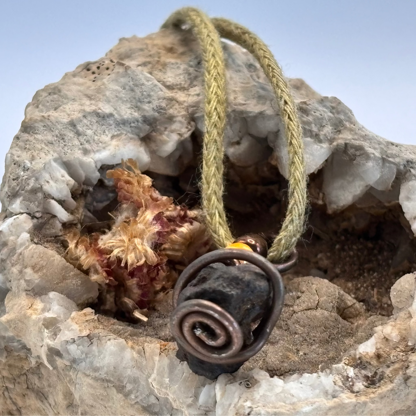 Close-up of copper wire wrapped iron ore stone, compact pendant