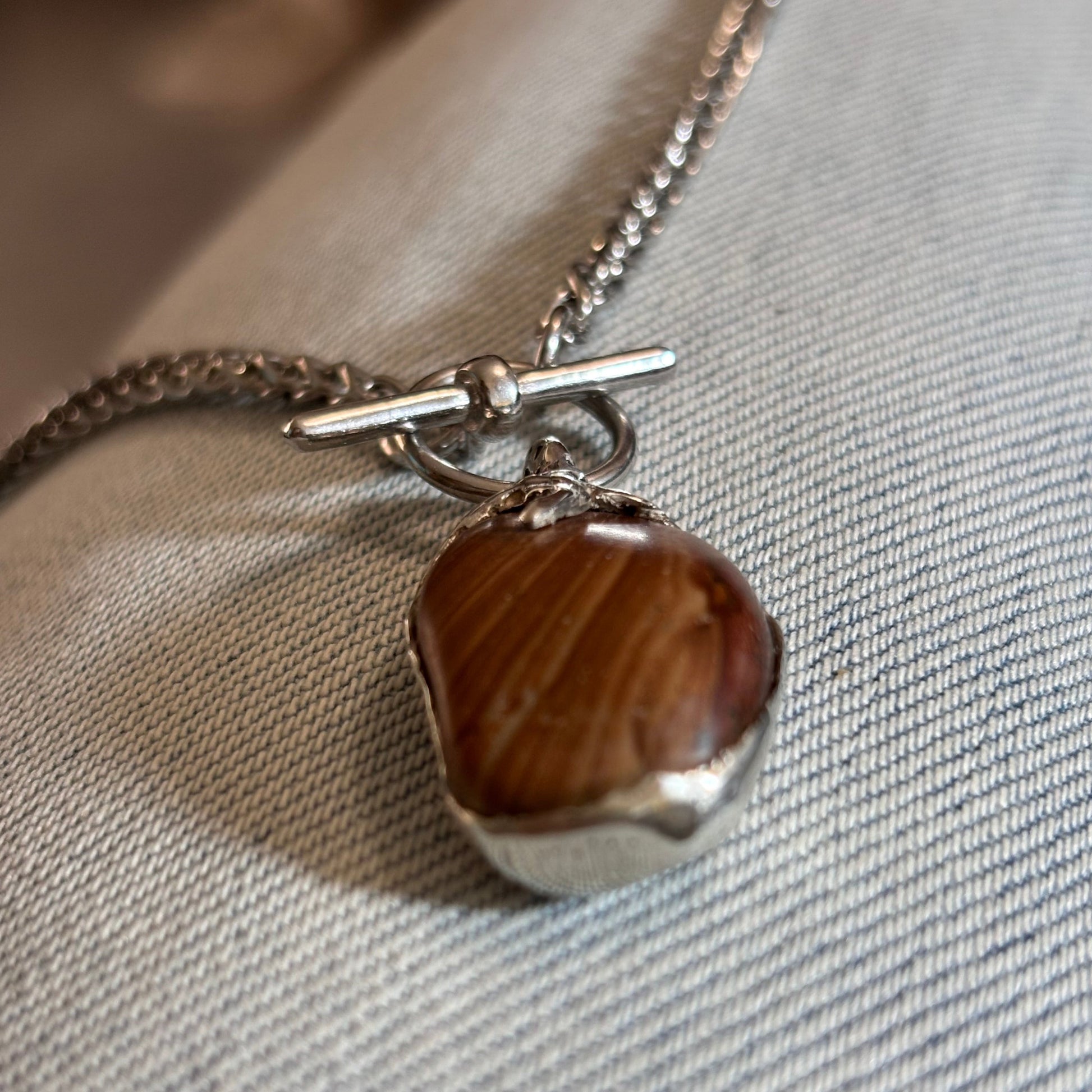 Oval striped stone necklace in sterling silver bezel setting with claw detail. Toggle clasp chain. Handmade jewelry from Lebanon