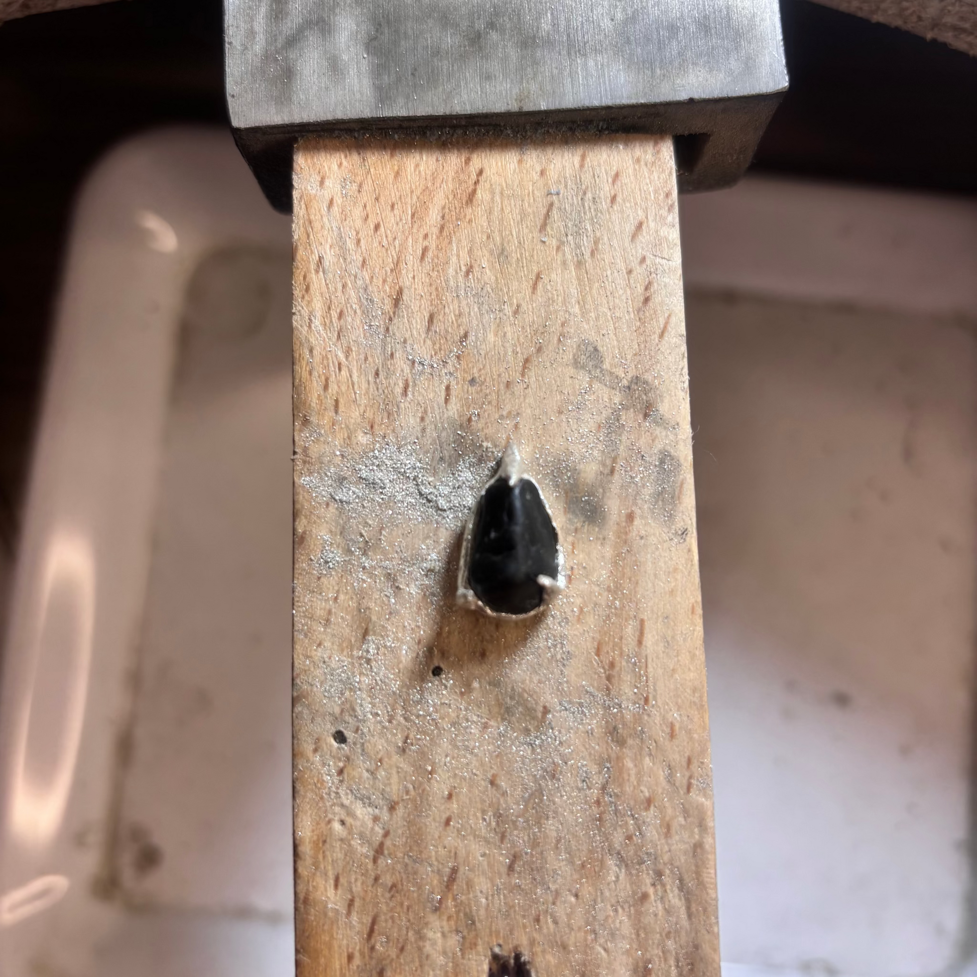 Silver prongs holding a black beach stone, detail shot