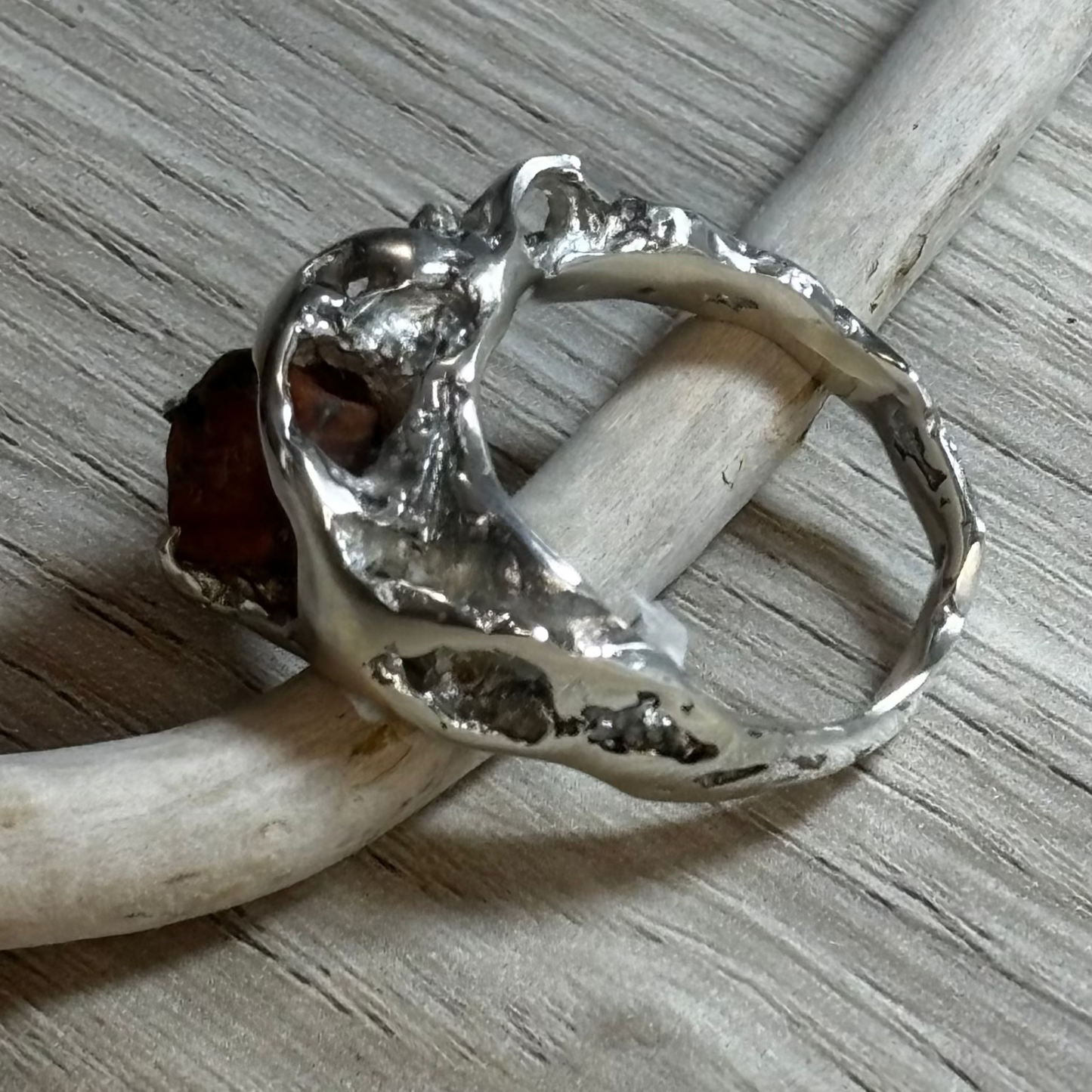 Silver ring with holes echoing natural rock formations