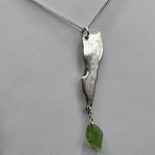 Silver necklace with a green pendant on a light gray background
