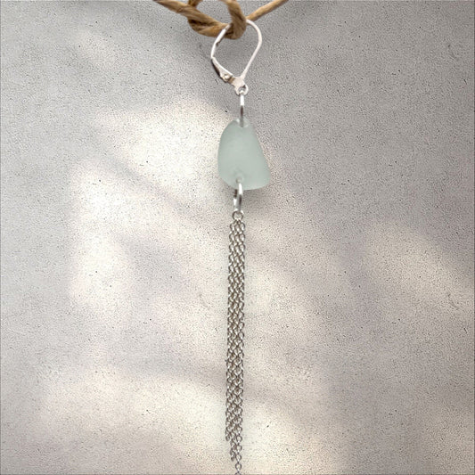 Sea glass pendant with chain on a textured surface