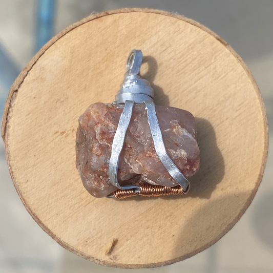 Close-up of aluminum wire wrapped raw stone pendant