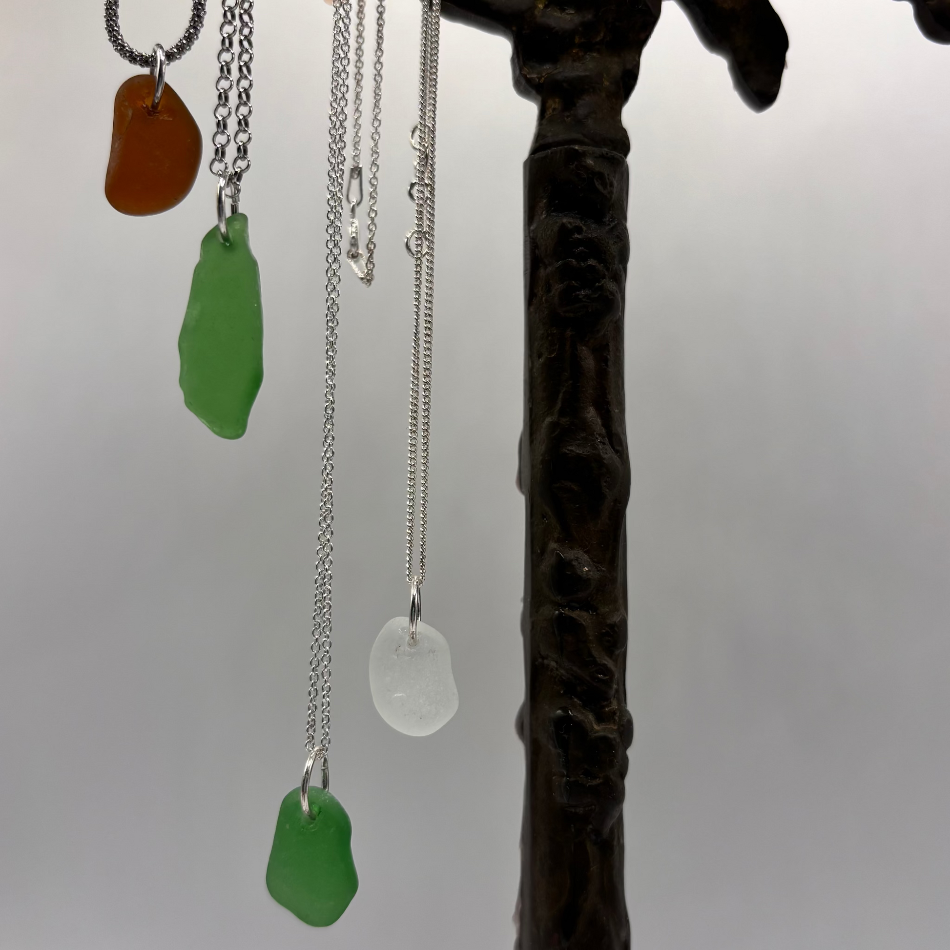 sea glass pendant set in silver on a delicate chain, with soft sea-shaped edges and a natural translucent glow.