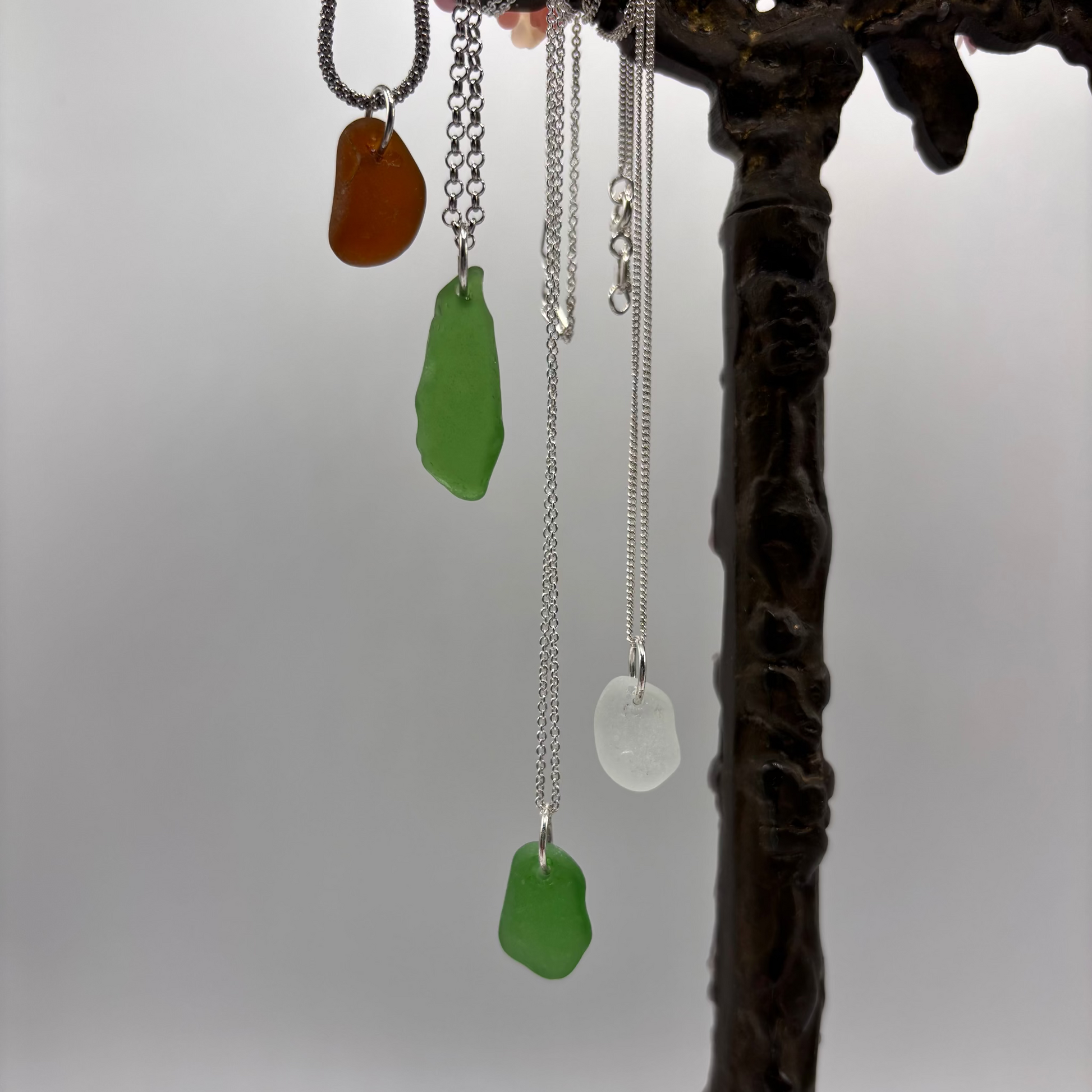 sea glass pendant set in silver on a silver chain, with soft sea-shaped edges and a natural translucent glow.
