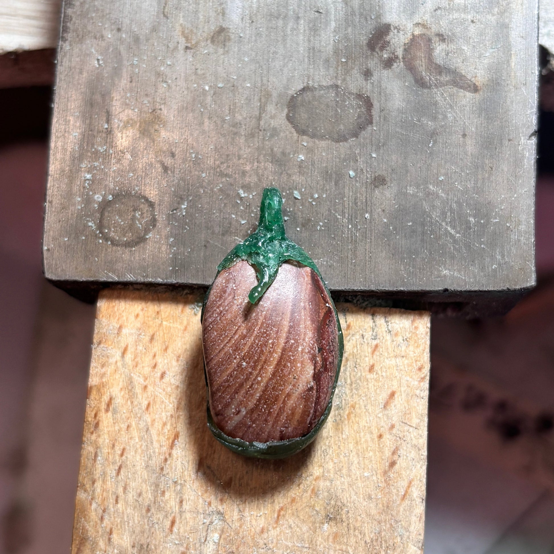 Close-up of natural striping on oval brown stone bezel pendant in wax version