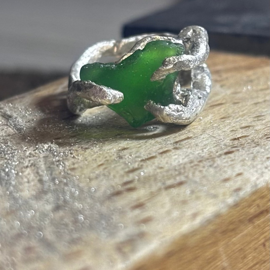 Close-up of green sea glass stone in silver ring setting