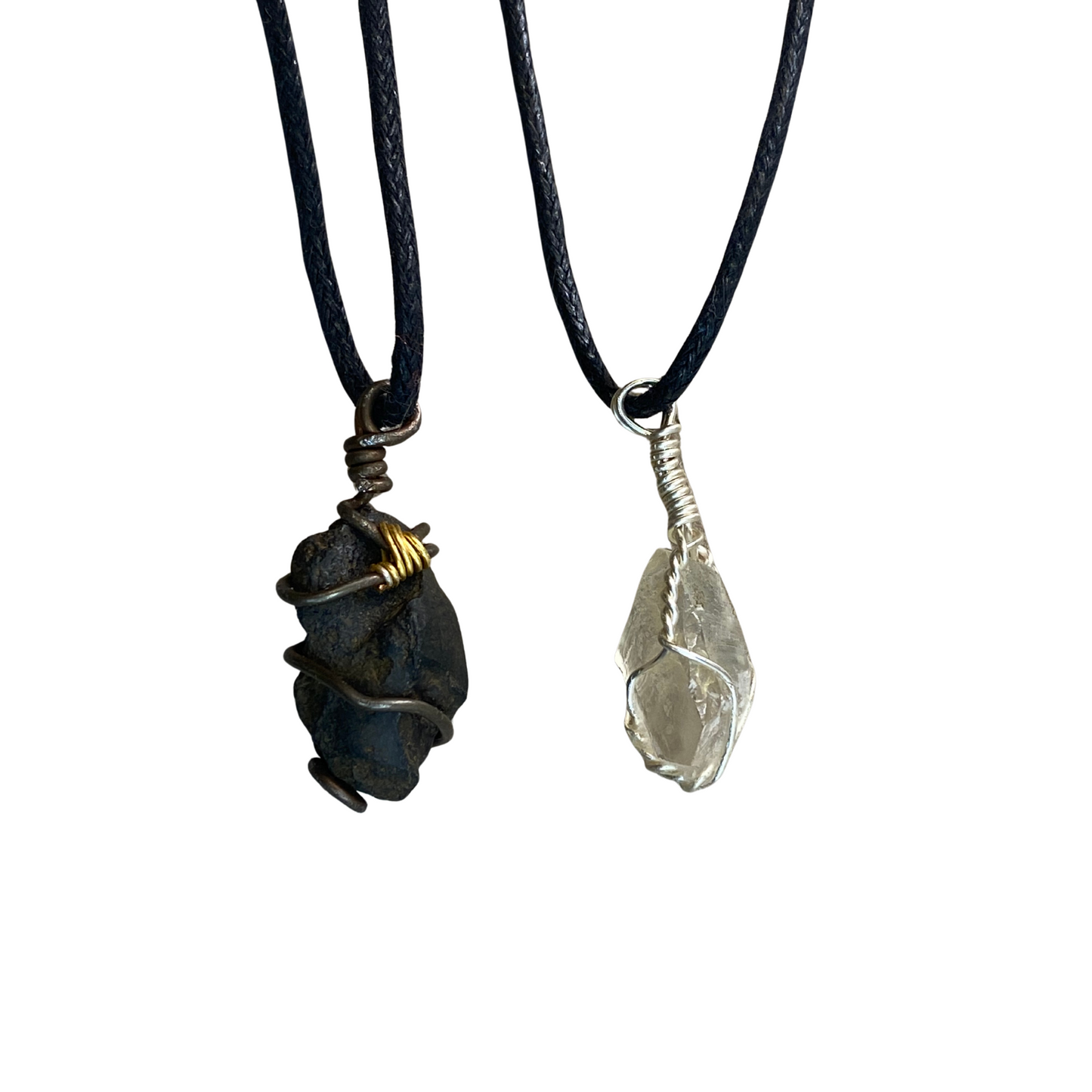 Two stone pendants one white one black on black cords against a white background